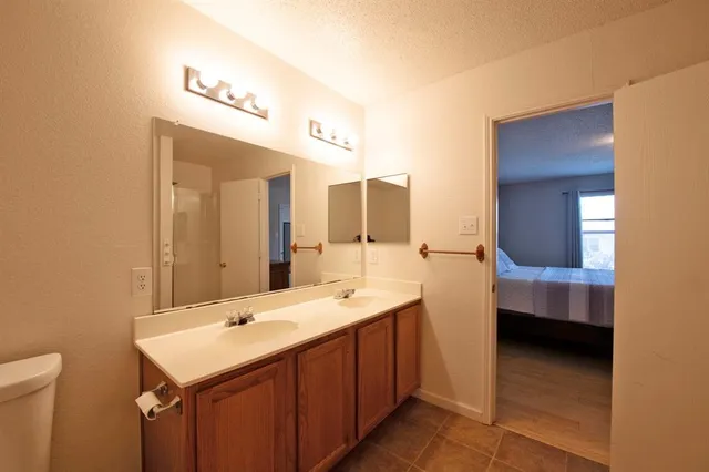 a bathroom with a double vanity sink toilet a mirror and shower