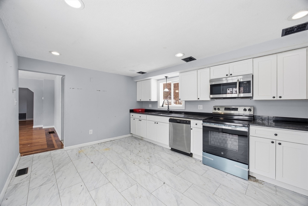 2230 Cranberry Highway, Unit A Wareham, MA 02576 - Photo 4 of 25 a kitchen with granite countertop white cabinets and stainless steel appliances
