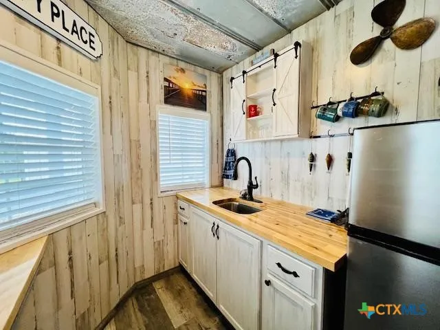 a kitchen with stainless steel appliances granite countertop a sink and a refrigerator