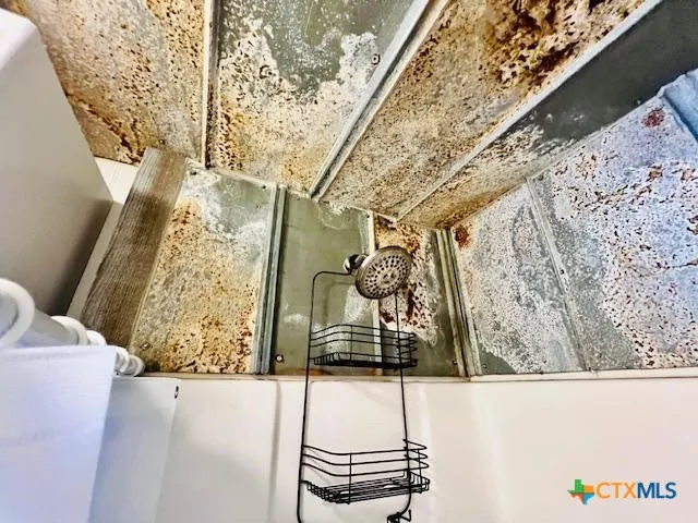 a bathroom with a sink a toilet a mirror and shower