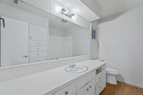 a spacious bathroom with a granite countertop sink and a mirror