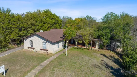 a view of a house with a backyard and trees