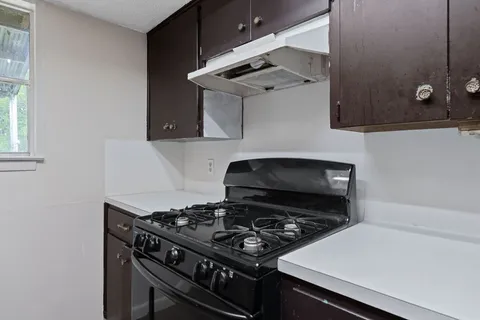a stove top oven sitting inside of a kitchen