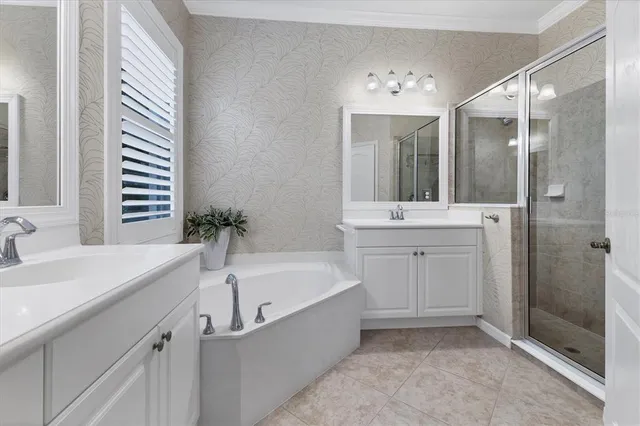 a en suite spacious bathroom with a tub double sink and mirror