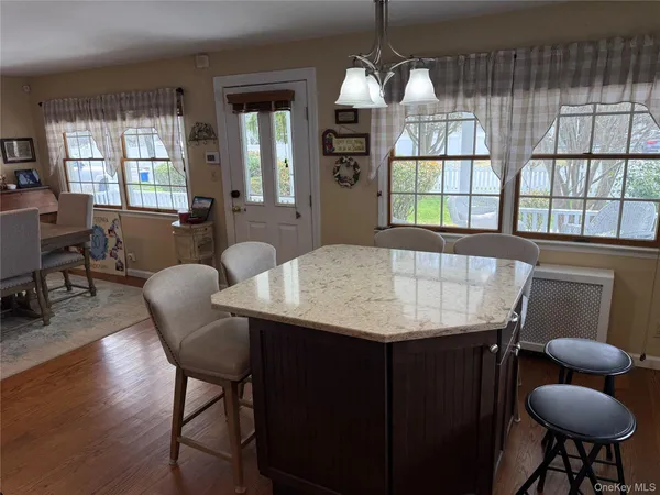a kitchen with stainless steel appliances granite countertop a table chairs microwave and sink