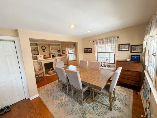 a living room with stainless steel appliances furniture a rug and a kitchen view