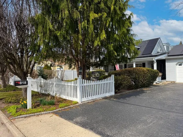 a view of a house with a small yard and wooden fence