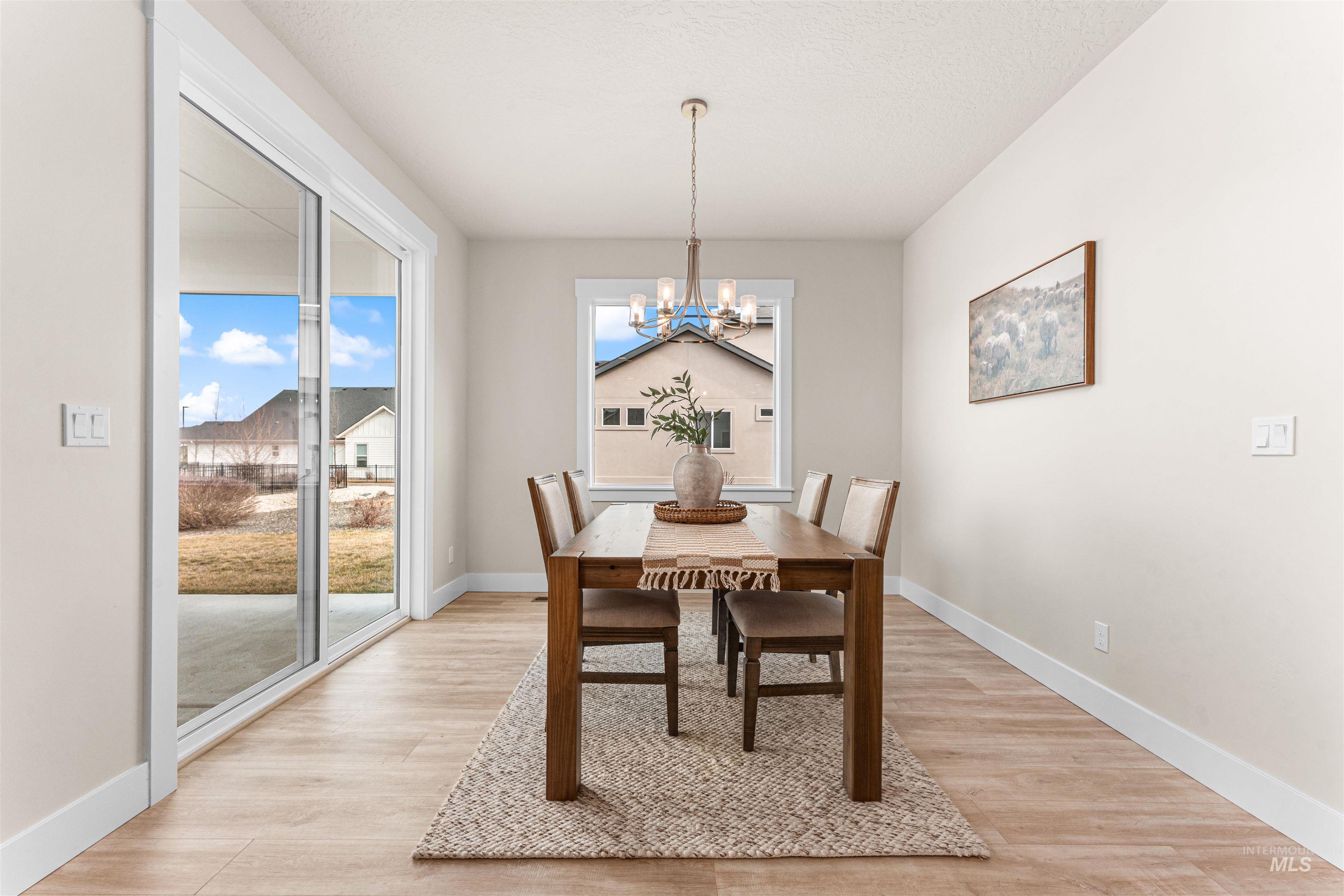 8082 Tandy Cv Street Middleton, ID 83644 - Photo 13 of 37 Dining area featuring a chandelier, light wood-style floors, and a textured ceiling