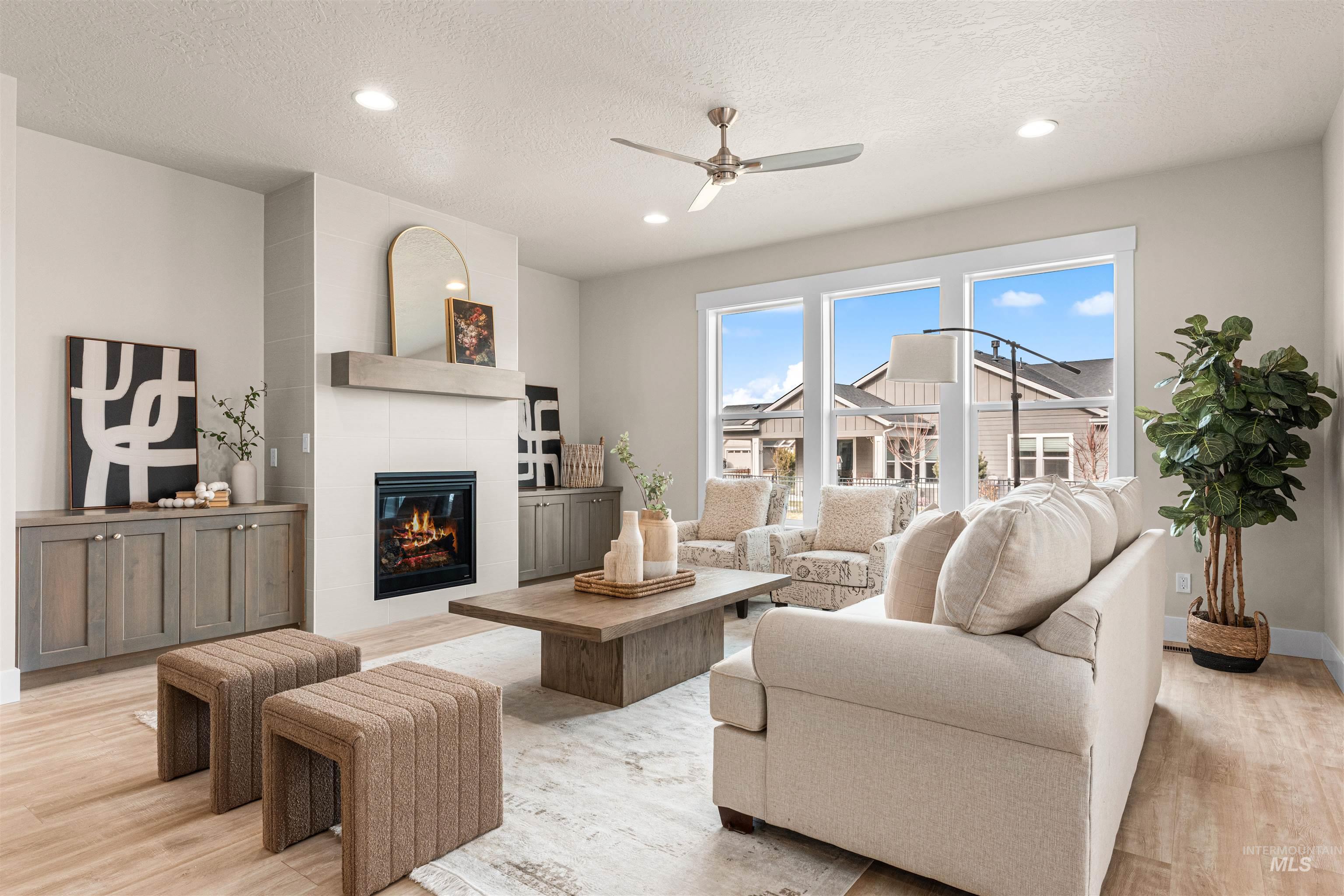 8082 Tandy Cv Street Middleton, ID 83644 - Photo 2 of 37 Living area with ceiling fan, light wood-type flooring, a tiled fireplace, recessed lighting, and a textured ceiling