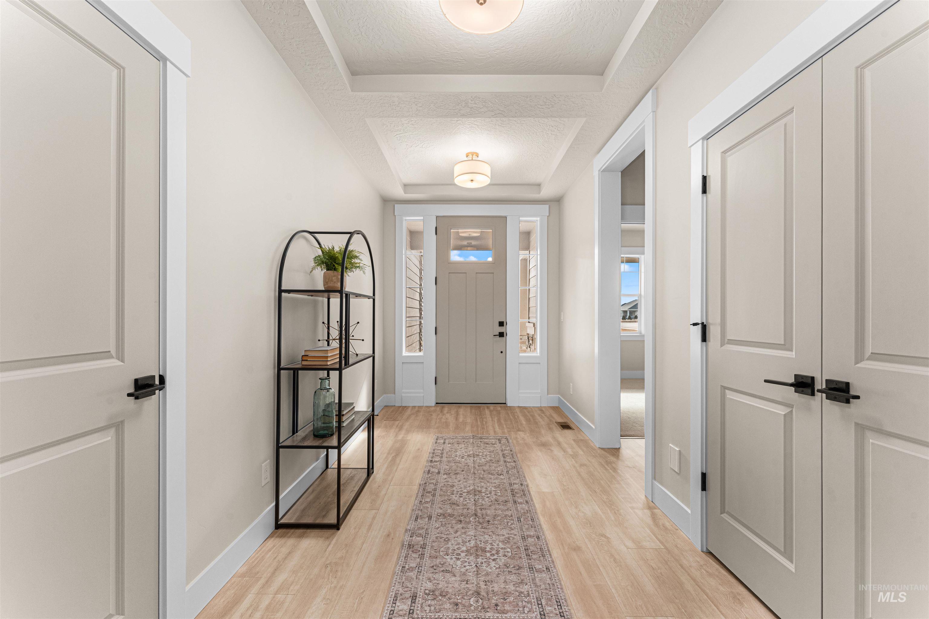 8082 Tandy Cv Street Middleton, ID 83644 - Photo 22 of 37 Foyer entrance featuring light wood finished floors, a tray ceiling, and a textured ceiling