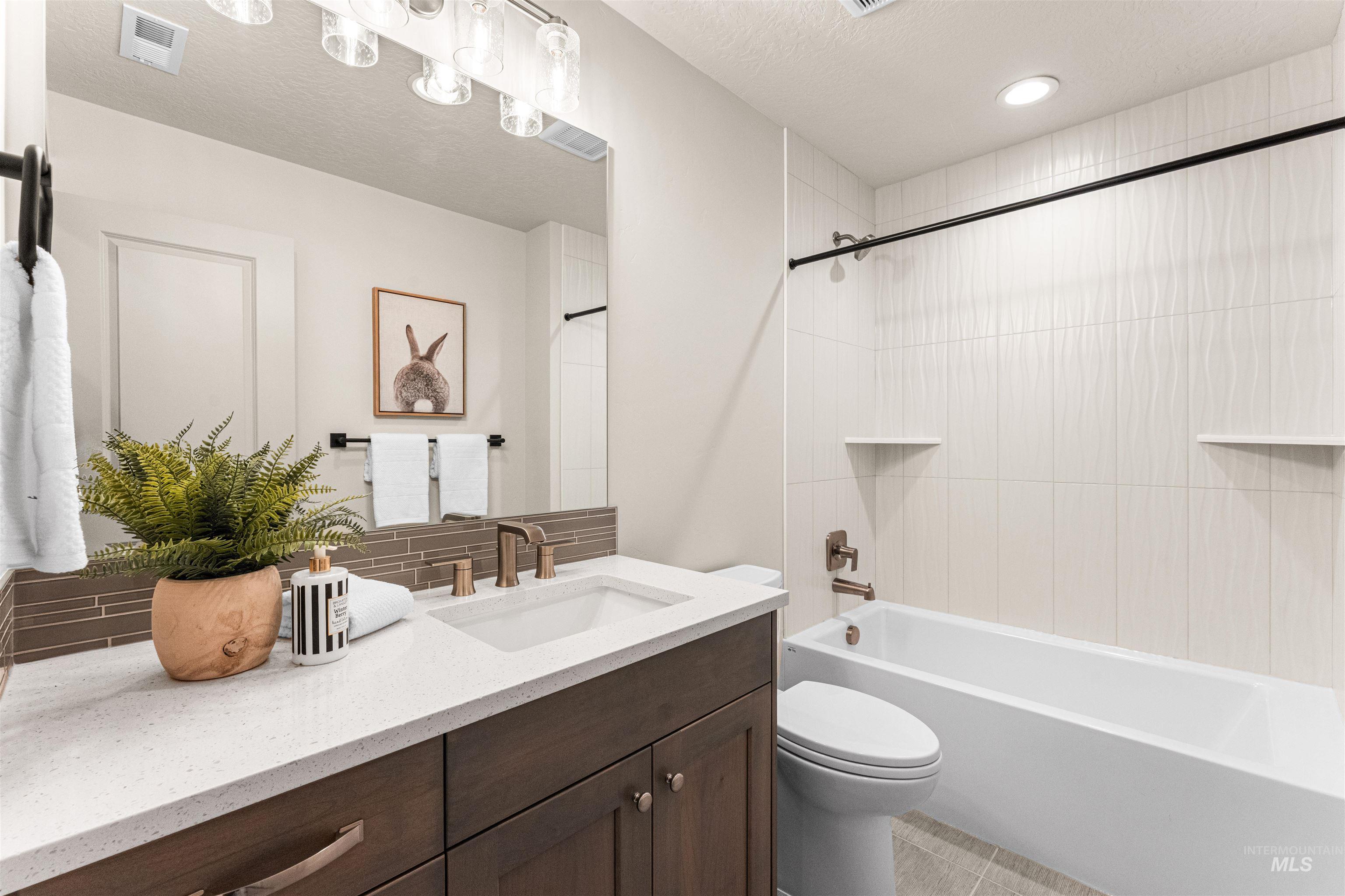 8082 Tandy Cv Street Middleton, ID 83644 - Photo 30 of 37 Full bathroom with vanity, tasteful backsplash, a textured ceiling, and shower combination