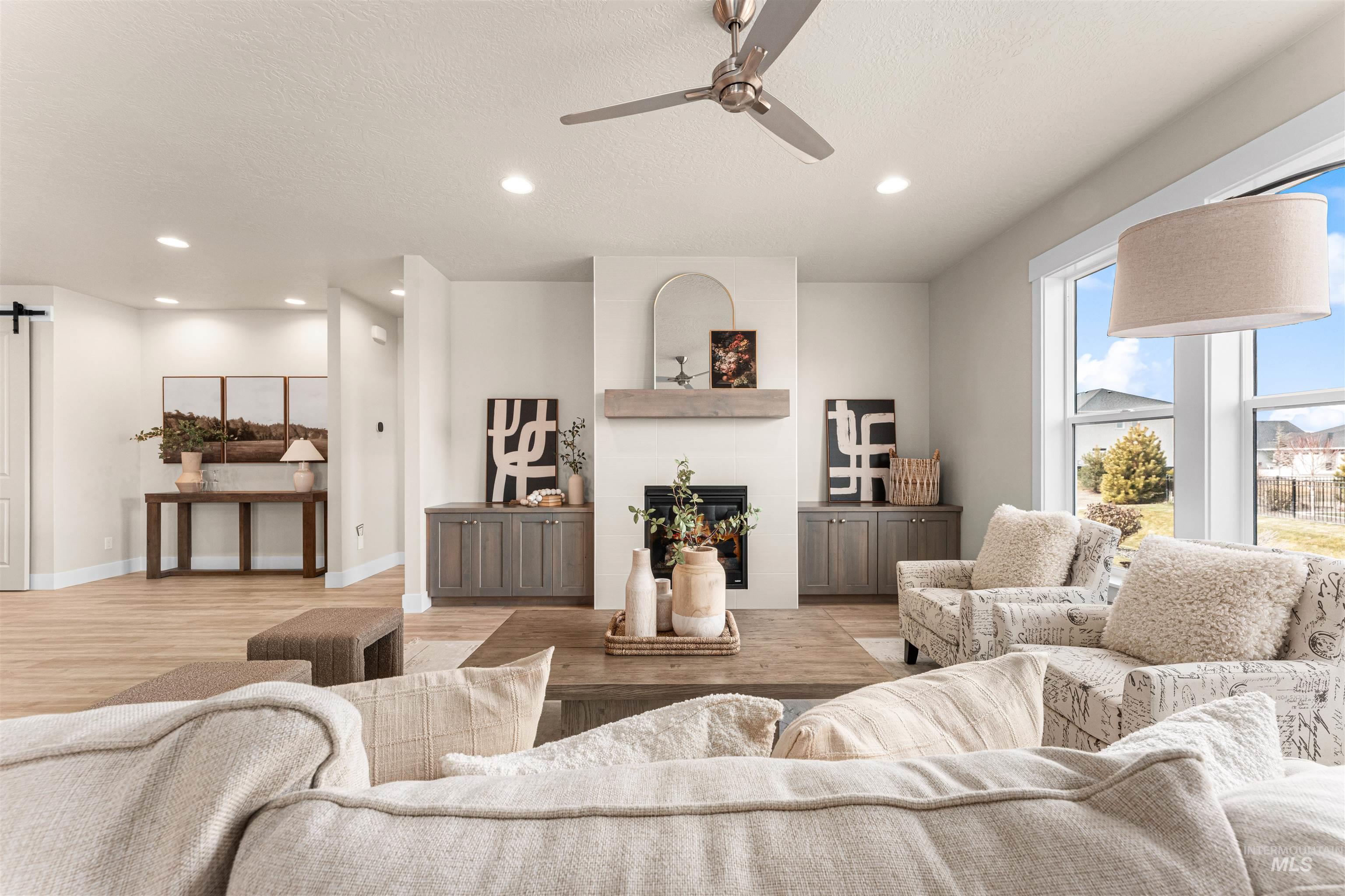 8082 Tandy Cv Street Middleton, ID 83644 - Photo 4 of 37 Living room featuring ceiling fan, a fireplace, light wood-style floors, a textured ceiling, and recessed lighting
