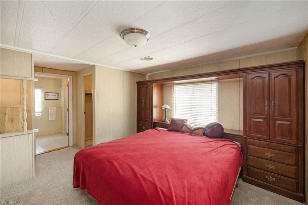 21 San Lu Rue Avenue, Unit 21 Naples, FL 34104 - Photo 11 of 33 a bed sitting in a bedroom next to a window