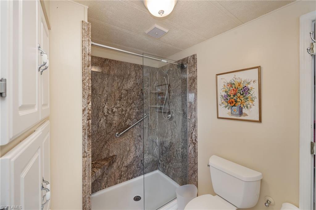 21 San Lu Rue Avenue, Unit 21 Naples, FL 34104 - Photo 17 of 33 a bathroom with a toilet and a shower
