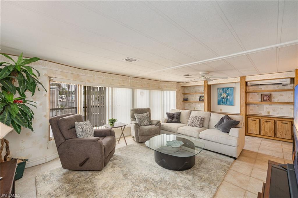 21 San Lu Rue Avenue, Unit 21 Naples, FL 34104 - Photo 2 of 33 a living room with furniture and a large window