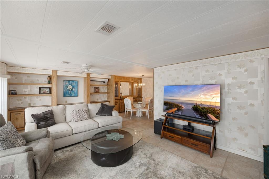 21 San Lu Rue Avenue, Unit 21 Naples, FL 34104 - Photo 3 of 33 a living room with furniture and a flat screen tv