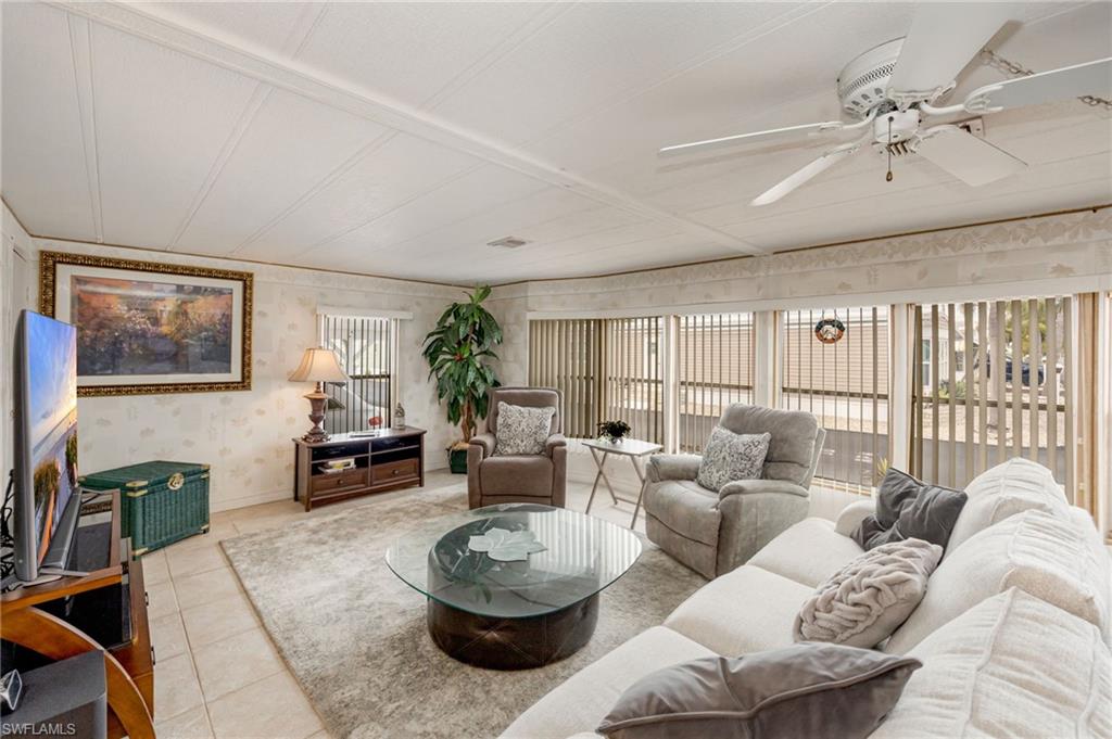 21 San Lu Rue Avenue, Unit 21 Naples, FL 34104 - Photo 5 of 33 a living room with furniture and a large window