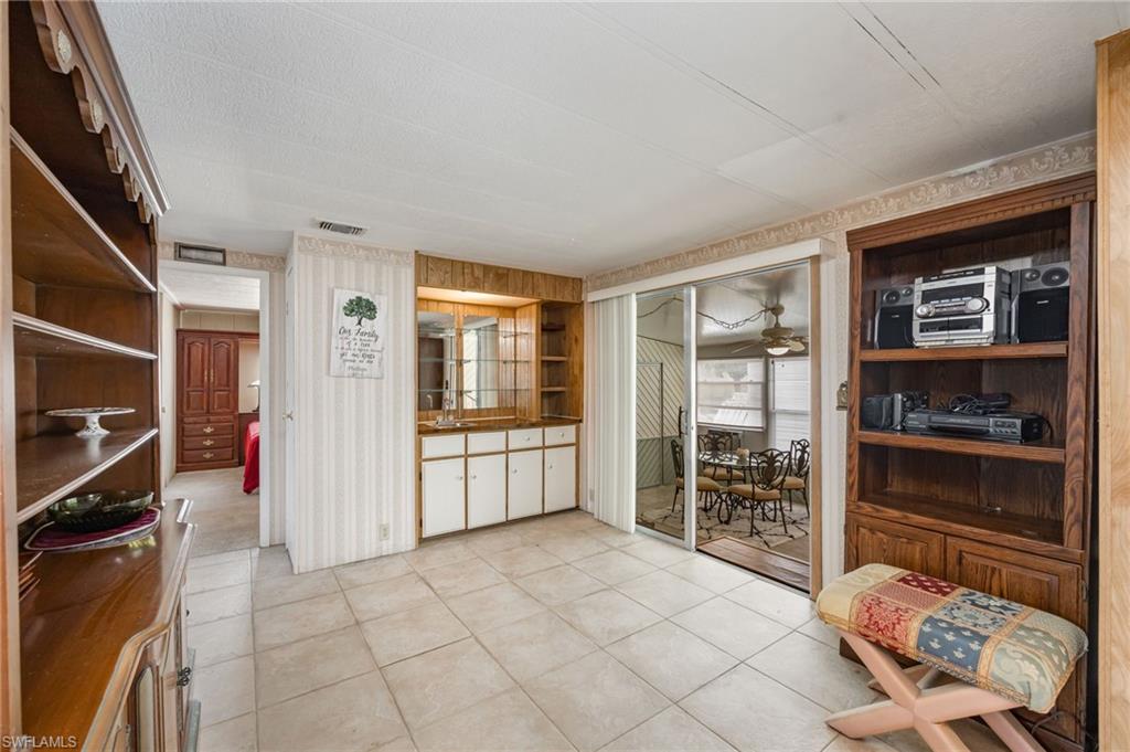 21 San Lu Rue Avenue, Unit 21 Naples, FL 34104 - Photo 6 of 33 a spacious bedroom with a bed and a window