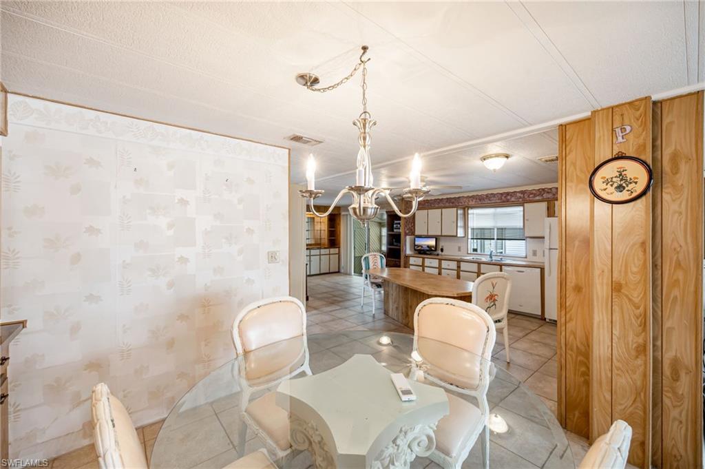 21 San Lu Rue Avenue, Unit 21 Naples, FL 34104 - Photo 10 of 33 a dining room with furniture and wooden floor