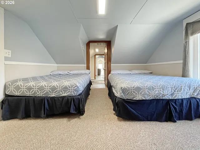 a bedroom with two beds and dresser