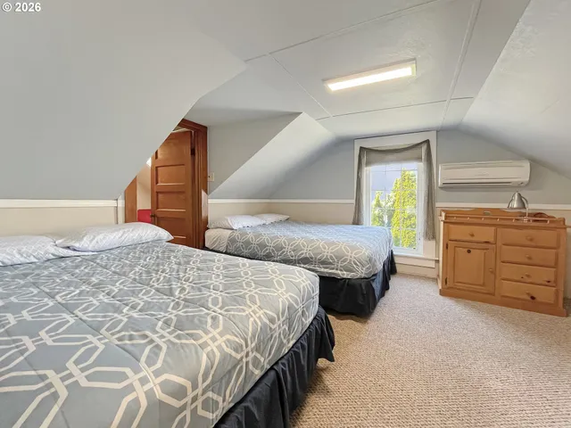 a bedroom with two beds and a window