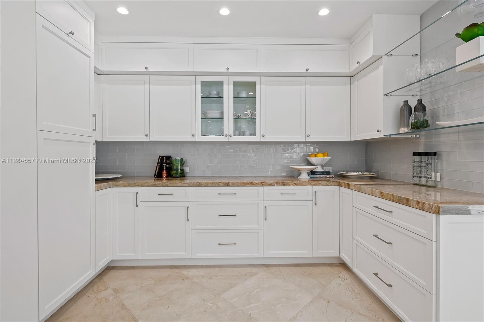 4845 Davis Road Miami, FL 33143 - Photo 14 of 34 a kitchen with granite countertop white cabinets and stainless steel appliances