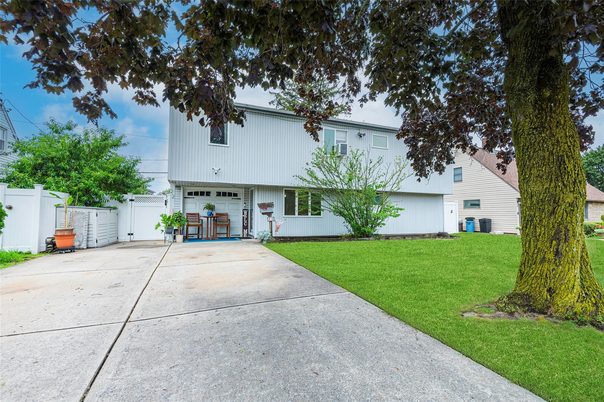 View of front facade featuring driveway, a gate, and an attached garage