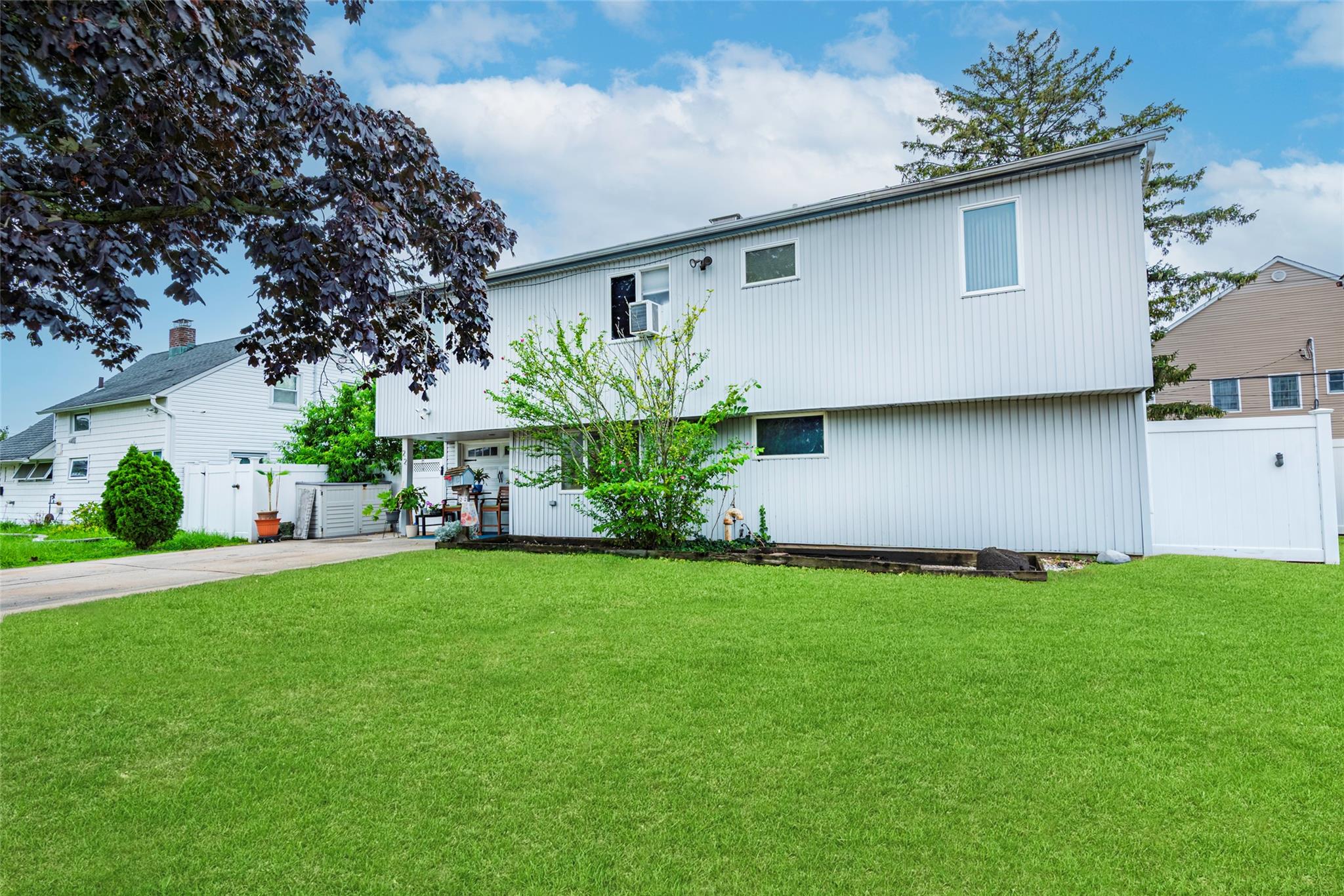 22 Lowland Road Levittown, NY 11756 - Photo 3 of 38 Colonial home with a gate and concrete driveway