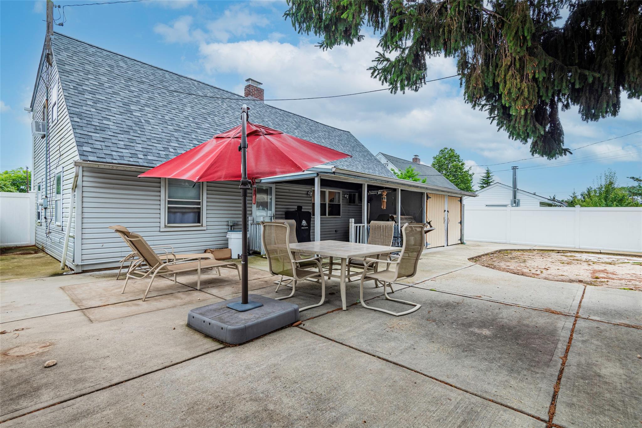 22 Lowland Road Levittown, NY 11756 - Photo 32 of 38 Rear view of house featuring roof with shingles, a patio area, outdoor dining space, and a chimney