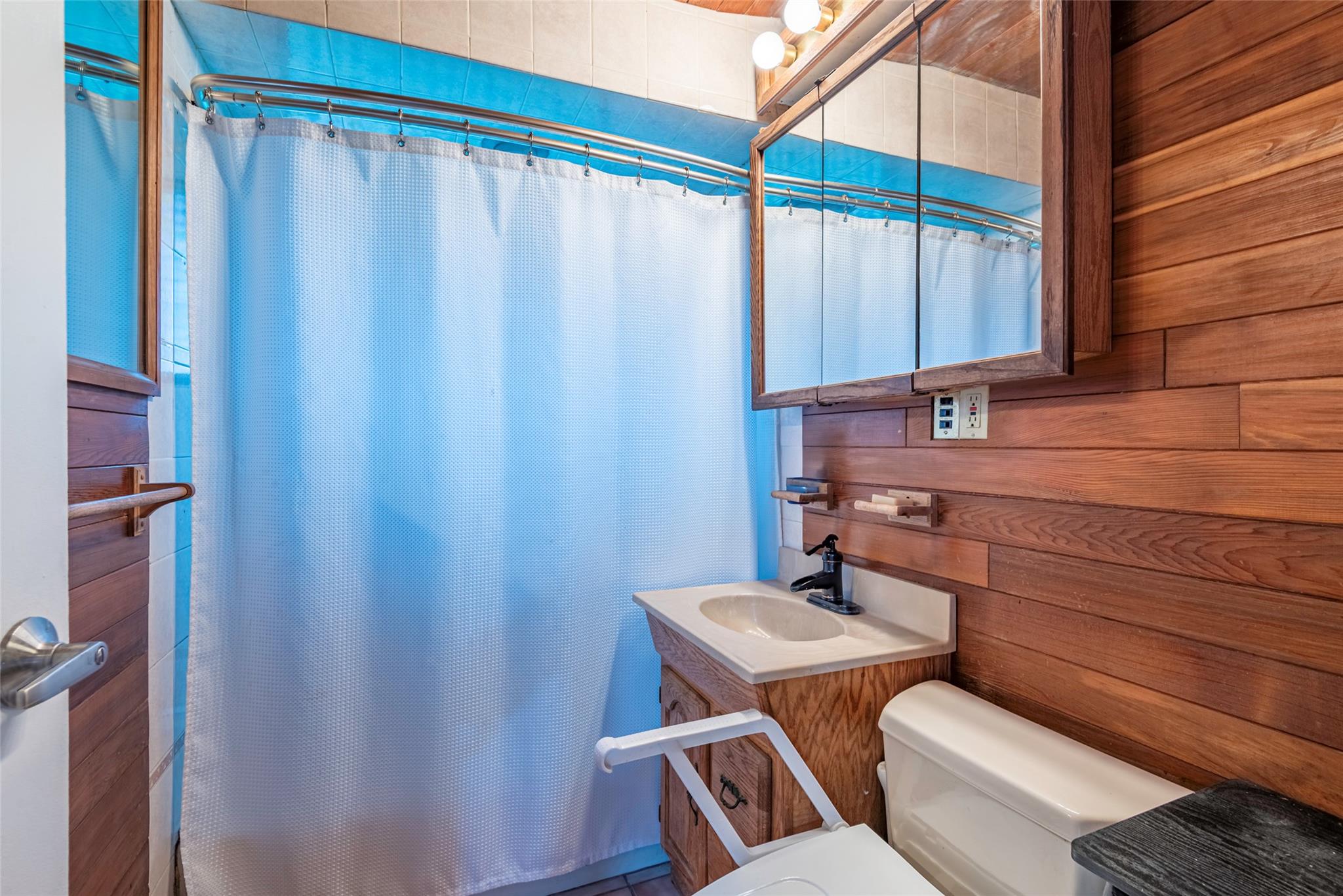 22 Lowland Road Levittown, NY 11756 - Photo 10 of 38 Bathroom with wood walls, a shower with curtain, and vanity