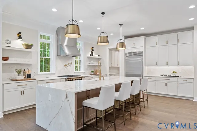 a large kitchen with kitchen island a stove a sink a center island and windows