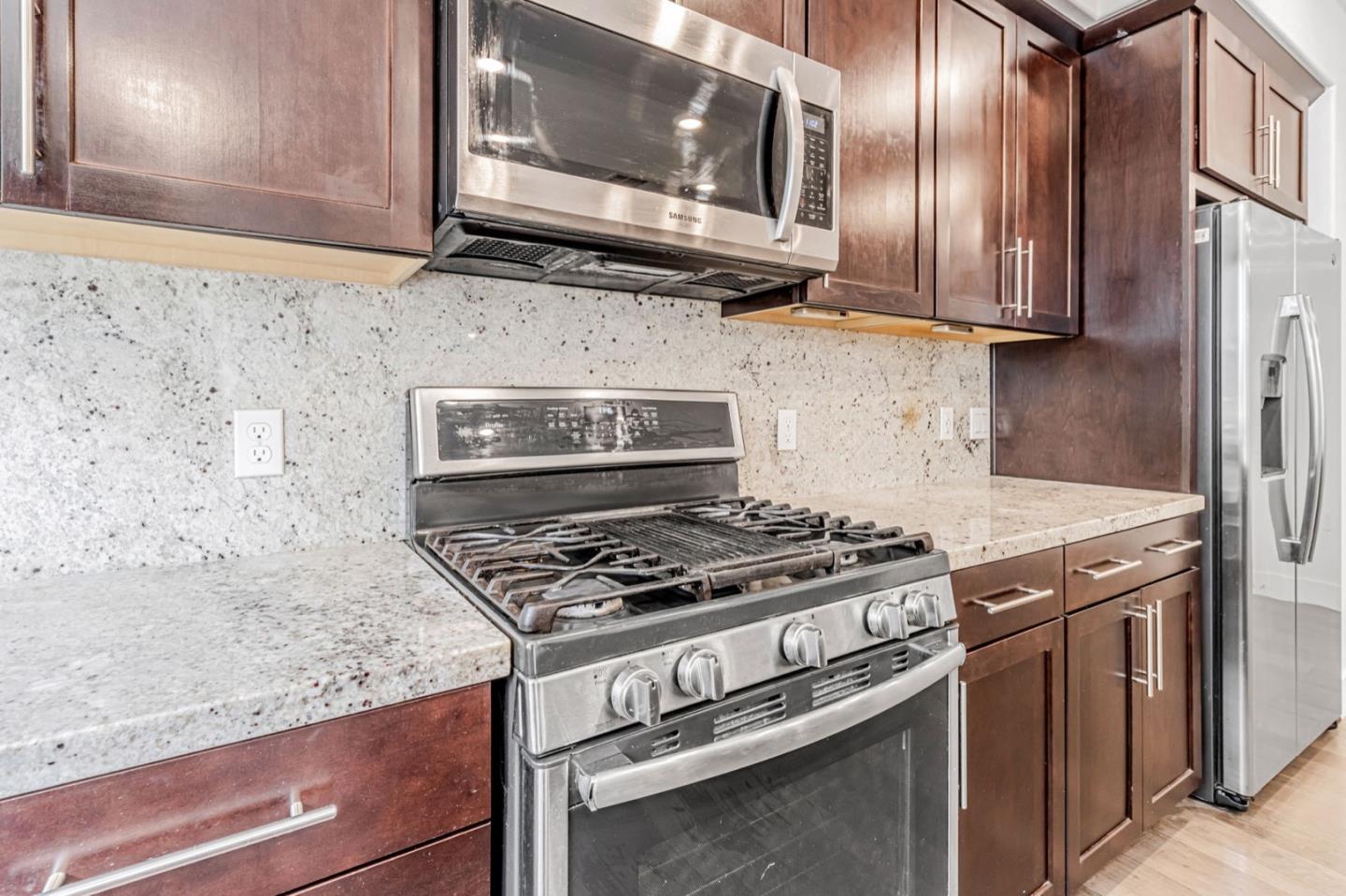 380 Riesling Avenue, Unit 21 Milpitas, CA 95035 - Photo 14 of 37 a kitchen with granite countertop a stove and a microwave