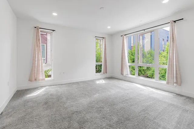a view of a big room with windows and chandelier fan