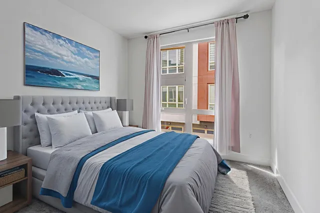 a bedroom with a bed and a painting on the wall