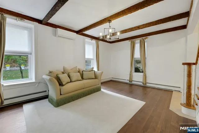 an empty room with wooden floor a ceiling fan and windows