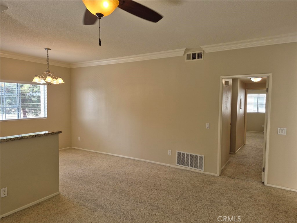 777 South Citrus Avenue, Unit 119 Azusa, CA 91702 - Photo 6 of 18 an empty room with chandelier fan and windows