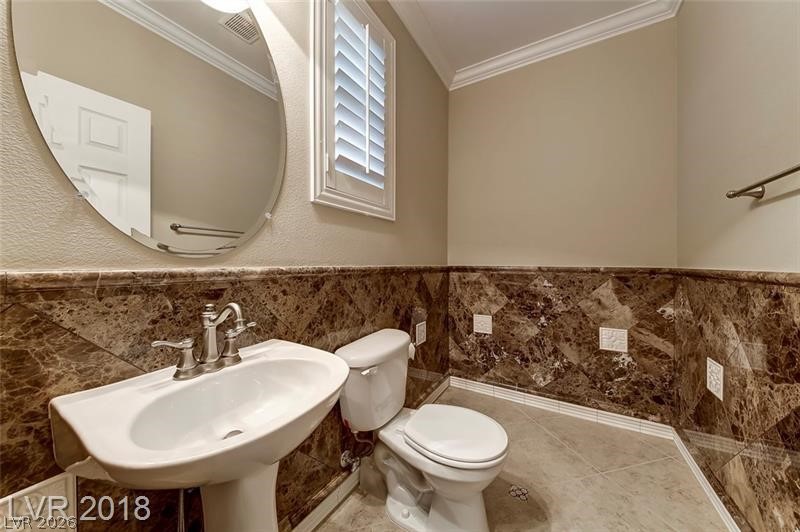 3144 Whitfeild Avenue Henderson, NV 89044 - Photo 30 of 55 A sleek, contemporary half-bath with rich marble wainscoting and classic crown molding.