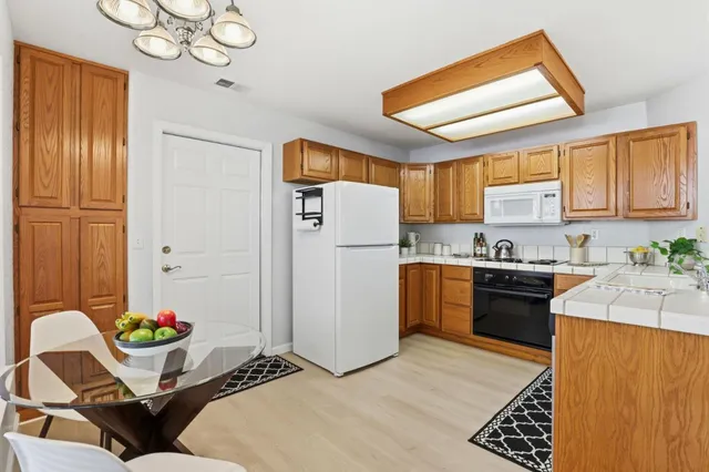 a kitchen with a refrigerator and a stove top oven
