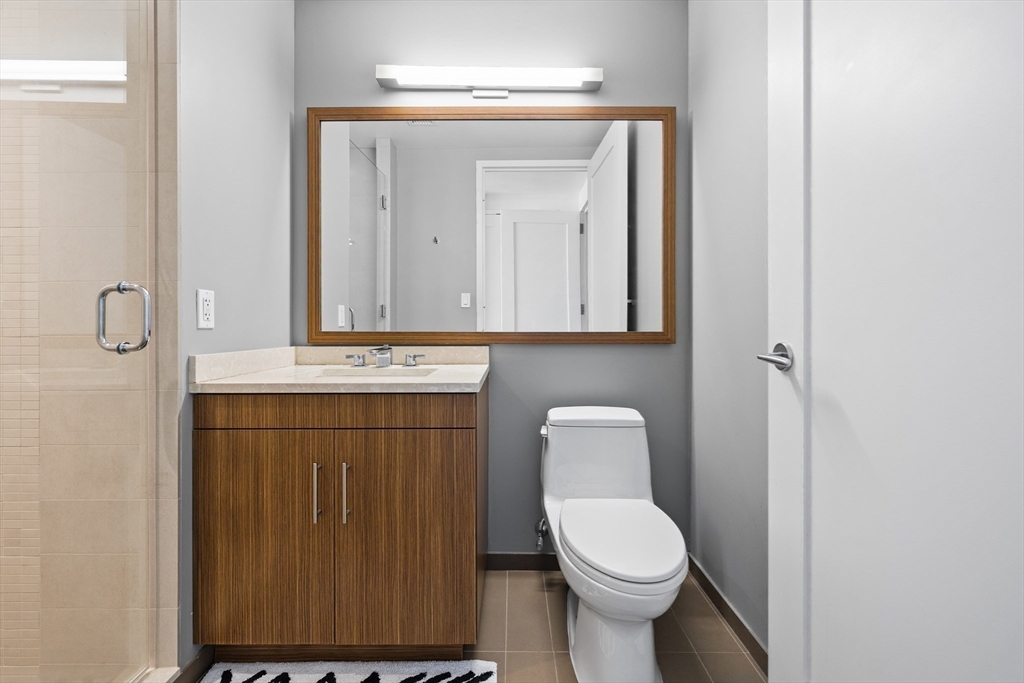 580 Washington Street, Unit PH5 Boston, MA 02111 - Photo 20 of 37 a bathroom with a toilet sink and mirror