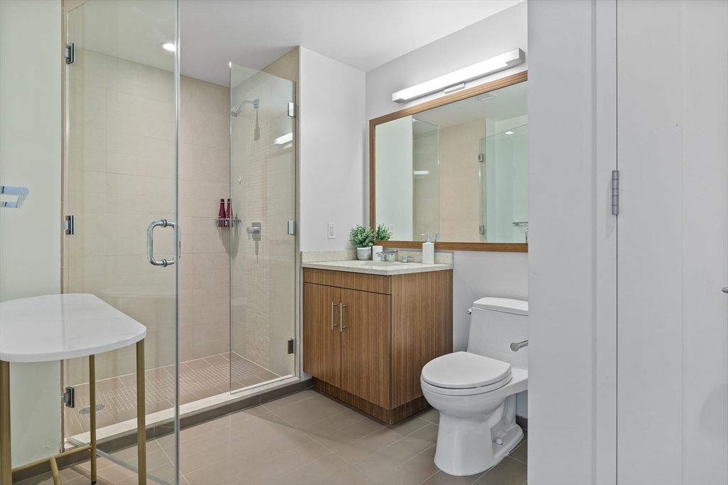 580 Washington Street, Unit PH5 Boston, MA 02111 - Photo 23 of 37 a bathroom with a toilet a sink and mirror