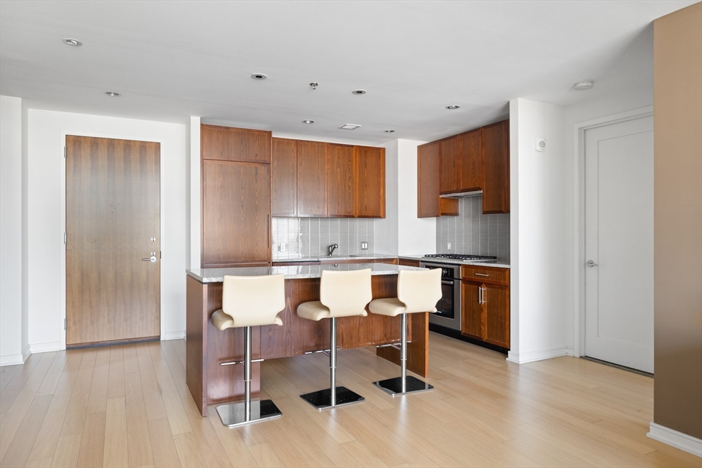 580 Washington Street, Unit PH5 Boston, MA 02111 - Photo 9 of 37 a kitchen with a dining table chairs and refrigerator