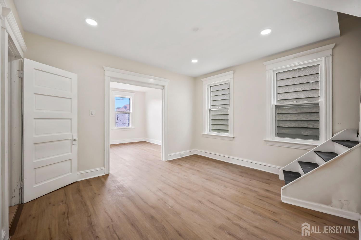 264 Barclay Street Perth Amboy, NJ 08861 - Photo 19 of 45 an empty room with wooden floor and windows