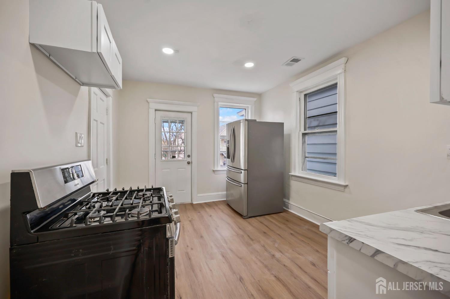 264 Barclay Street Perth Amboy, NJ 08861 - Photo 27 of 45 a kitchen with a refrigerator and a stove top oven