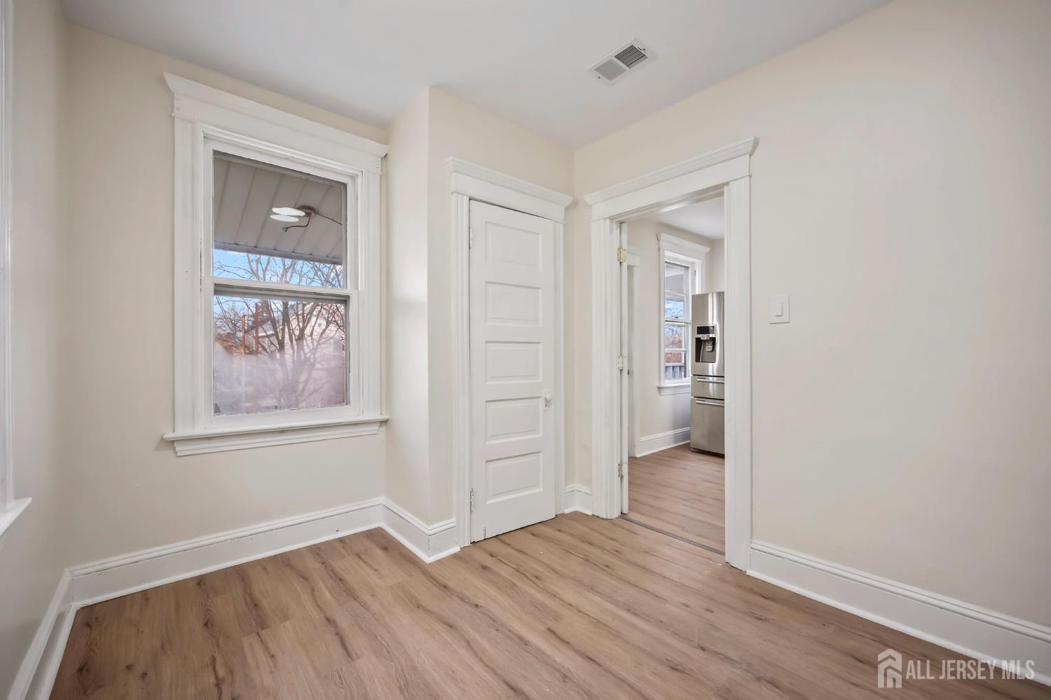 264 Barclay Street Perth Amboy, NJ 08861 - Photo 31 of 45 an empty room with wooden floor and windows