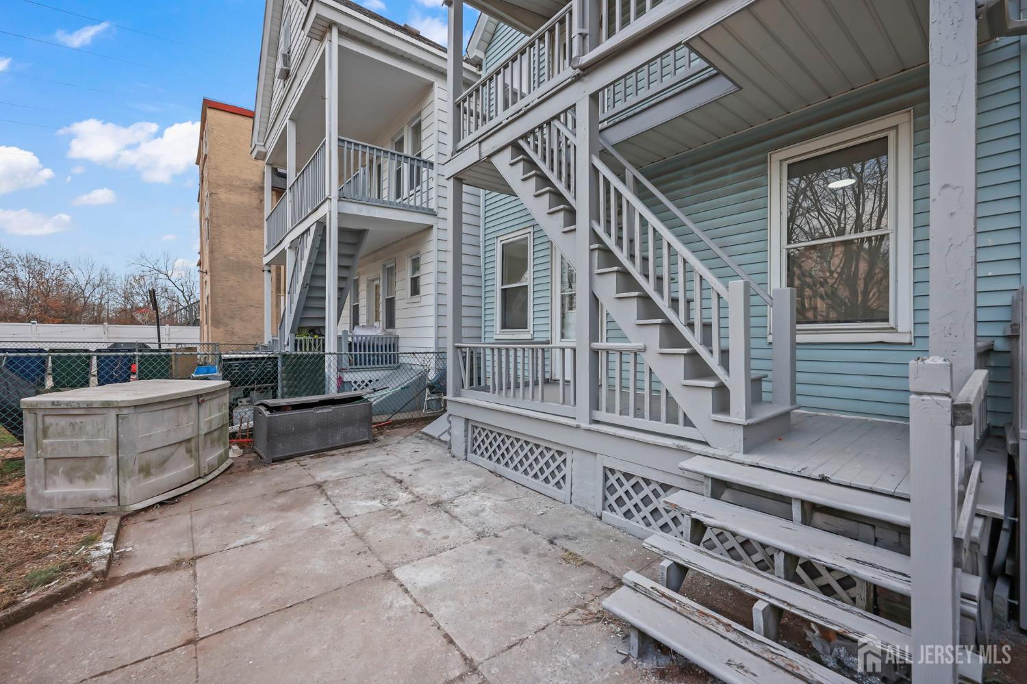 264 Barclay Street Perth Amboy, NJ 08861 - Photo 39 of 45 a view of a patio with couches table and chairs with wooden floor and fence