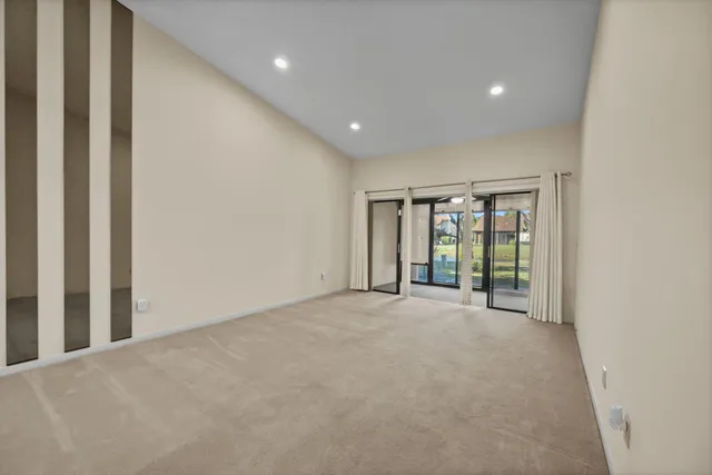 an empty room with fan and windows