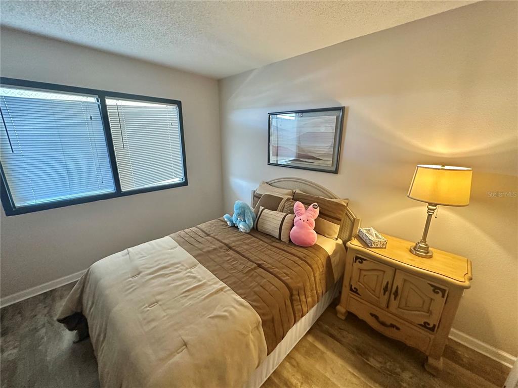 6035 Sea Ranch Drive, Unit 410 Hudson, FL 34667 - Photo 19 of 64 a bedroom with a bed and lamp