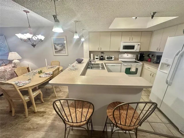 a kitchen with a refrigerator sink and cabinets