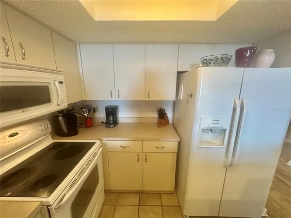 a kitchen with stainless steel appliances kitchen island granite countertop a sink a stove a dining table and chairs