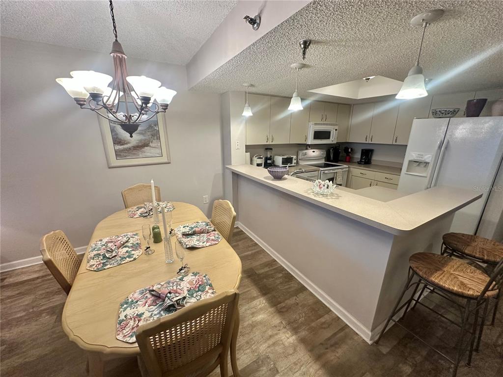 6035 Sea Ranch Drive, Unit 410 Hudson, FL 34667 - Photo 6 of 64 a kitchen with stainless steel appliances kitchen island granite countertop a sink a stove a dining table and chairs